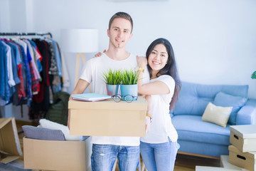 Young beautiful couple moving cardboard boxes at new home