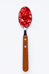 Spoon with pomegranate seeds isolated on white