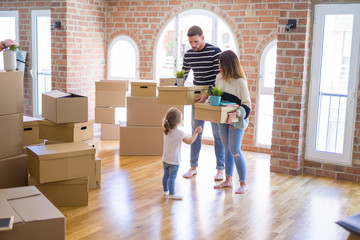 Beautiful famiily with kid moving cardboard boxes at new home