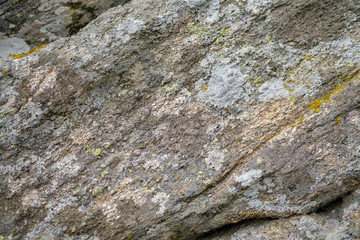 Close up of big old stones with natural mosses. Gray wild stones background with copy space. Сlean ecology concept. Grunge texture. Fragment of rock or mountain. 