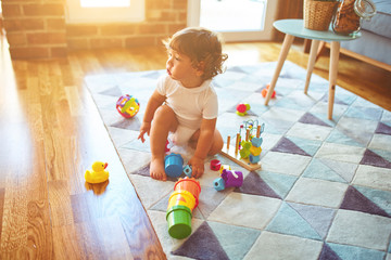 Beautiful toddler child girl playing with toys on the carpet