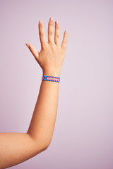 Arm of model woman with beautiful handmade colorful bracelet on wrist