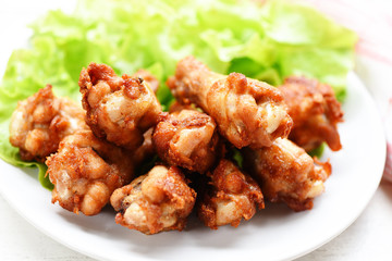 Fried chicken wings on white plate with garlic lemon chilli herbs spices and fresh lettuce vegetable salad - Baked chicken wings crispy