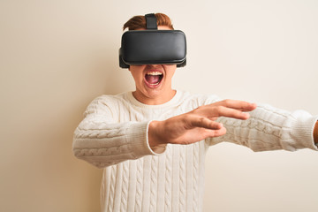 Young handsome teenager boy playing virtual reality game using goggles