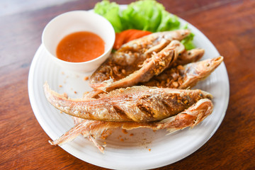 fried fish with vegetable salad tomato and sauce on white plate wooden table - freshwater fish Mekong River Other names Sheatfishes Siluriformes Siluridae