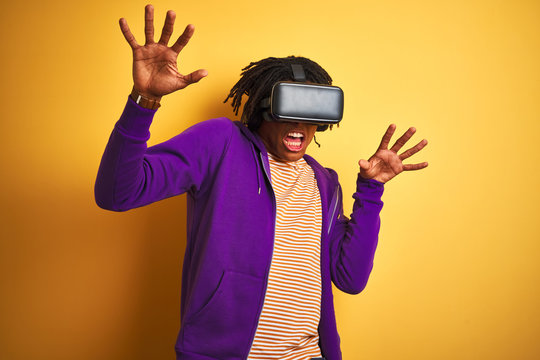 Young african american man playing virtual reality game using goggles
