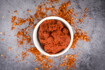 curry paste cayenne pepper and dried chilli peppers background - group of red hot chilli powder on black plate top view ingredients table asian food spicy in thailand