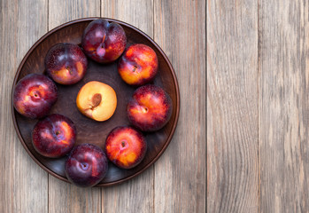 Red cherry plums on the wooden background.
