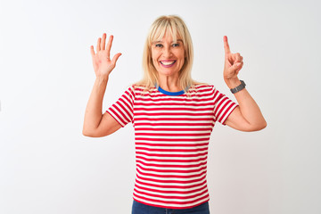 Fototapeta na wymiar Middle age woman wearing casual striped t-shirt standing over isolated white background showing and pointing up with fingers number six while smiling confident and happy.