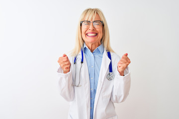 Middle age doctor woman wearing glasses and stethoscope over isolated white background excited for success with arms raised and eyes closed celebrating victory smiling. Winner concept.