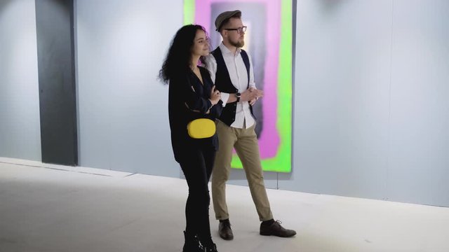 Two art gallery visitors talking about the painting