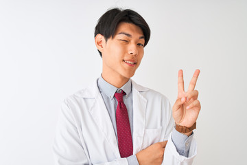 Chinese scientist man wearing tie and coat standing over isolated white background smiling with happy face winking at the camera doing victory sign. Number two.