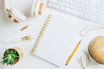 Woman modern workplace on white background. Flower, keyboard, headphones, pearl necklace, wooden box. Business accessories. Mock-up. Glamour style. Flat lay