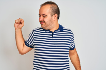 Young man wearing casual striped polo standing over isolated white background stretching back, tired and relaxed, sleepy and yawning for early morning