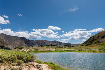 A beautiful mountain landscape with a lake surrounded by rocky mountains, and a bright blue sky...
