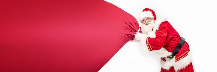 Real Santa Claus pulling large red gift sack.