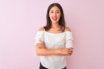 Fototapeta premium Beautiful chinese woman wearing white t-shirt standing over isolated pink background happy face smiling with crossed arms looking at the camera. Positive person.