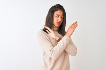 Beautiful chinese woman wearing turtleneck sweater standing over isolated white background Rejection expression crossing arms doing negative sign, angry face