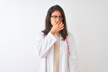 Chinese doctor woman wearing coat and pink stethoscope over isolated white background smelling something stinky and disgusting, intolerable smell, holding breath with fingers on nose. Bad smells 