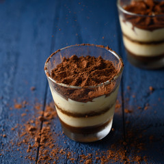 Tiramisu in a glass, sprinkled with chocolate. Freezing in motion. square photo