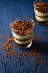 Tiramisu in a glass, sprinkled with chocolate. Freezing in motion.