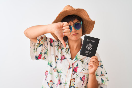 Tourist woman on vacation holding USA United States passport over isolated white background with angry face, negative sign showing dislike with thumbs down, rejection concept