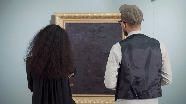 Visitors in art gallery talking about artwork