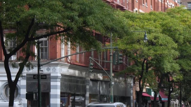 A daytime exterior establishing shot of typical red brick Manhattan apartment buildings.  	