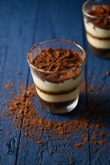 Tiramisu in a glass, sprinkled with chocolate. Freezing in motion.