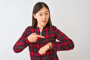 Young chinese woman wearing casual jacket standing over isolated white background In hurry pointing to watch time, impatience, upset and angry for deadline delay