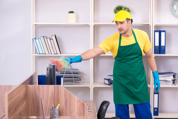 Young male contractor cleaning the office