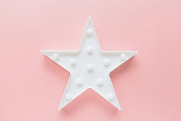 Star shaped white LED lights lamp single frame. Creative conceptual top view flat lay composition with copy space on pink background in minimal style. Overhead, template, mockup