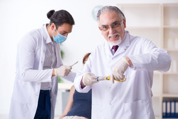 Two male doctors and young woman in plastic surgery concept