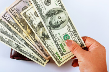 dollar bills in a female hand on a wallet.