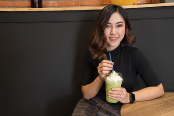 woman drinking green Tea frappe in cafe