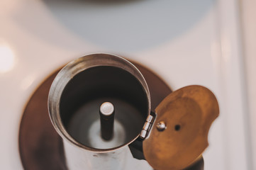 An empty coffee Turk is standing on the stove.