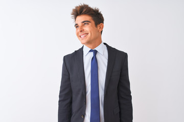Young handsome businessman wearing suit standing over isolated white background looking away to side with smile on face, natural expression. Laughing confident.