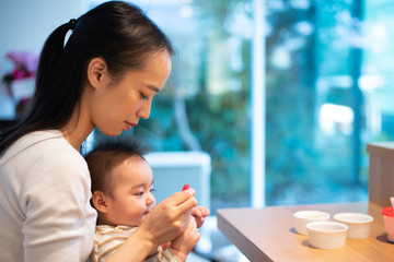 Mother feeding baby food to her baby.