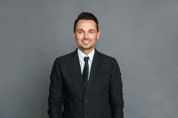 Businessman studio standing isolated on grey looking camera cheerful