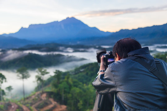Asia Photographer man taking picture of beautiful Mount Kinabalu, Sabah, Borneo with nature environment 