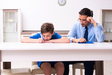 Fototapeta premium Busy father helping his son to prepare for exam