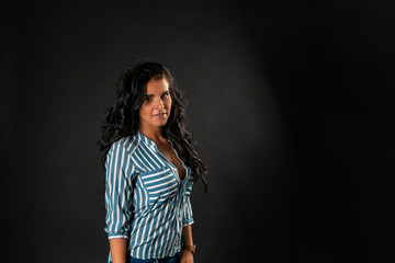 Portrait of a young beautiful brunette with piercing, on a black background