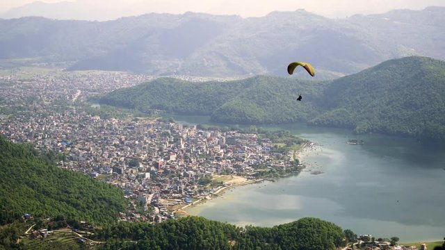 Paragliders flying against the Himalayas , Pokhara , Nepal.