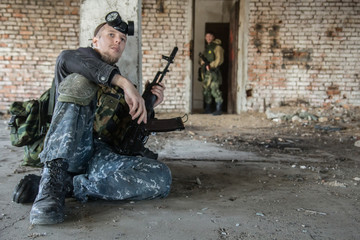 A military man in camo clothes (soldier of fortune) during an exchange of fire hides from enemies...