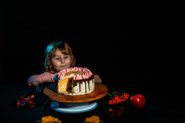 Little blonde girl child looks at the cake, autumn still life.