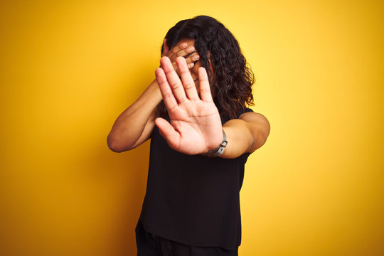 Transsexual transgender elegant businesswoman standing over isolated yellow background covering eyes with hands and doing stop gesture with sad and fear expression. Embarrassed and negative concept.