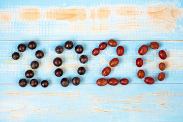 2020 Happy New Year and New You with fruits, Black grapes and Red grapes on blue wood background. Goals, Healthy, Healthcare, Resolution, trends, Time to New Start, fitness and dieting concept.