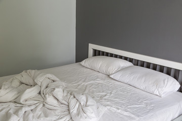 Two white pillow on bed with wrinkle messy blanket in bedroom