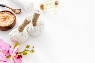 Massage thai herbal balls near spa accessories and orchids on white background space for text