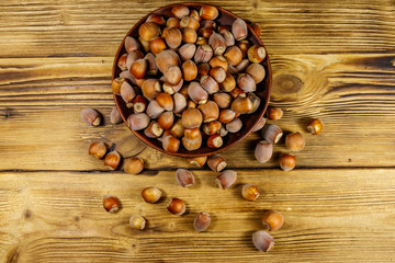 Hazelnuts in ceramic plate on a wooden table. Top view